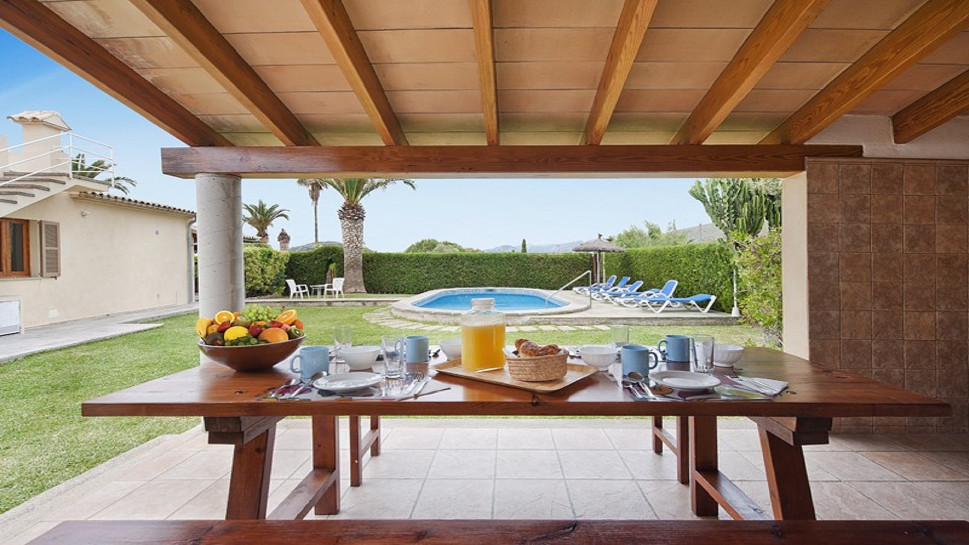 Mesa de picnic con una piscina la fondo en una villa